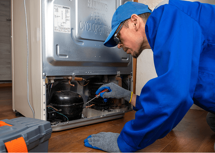 Appliance repairman fixing fridge components