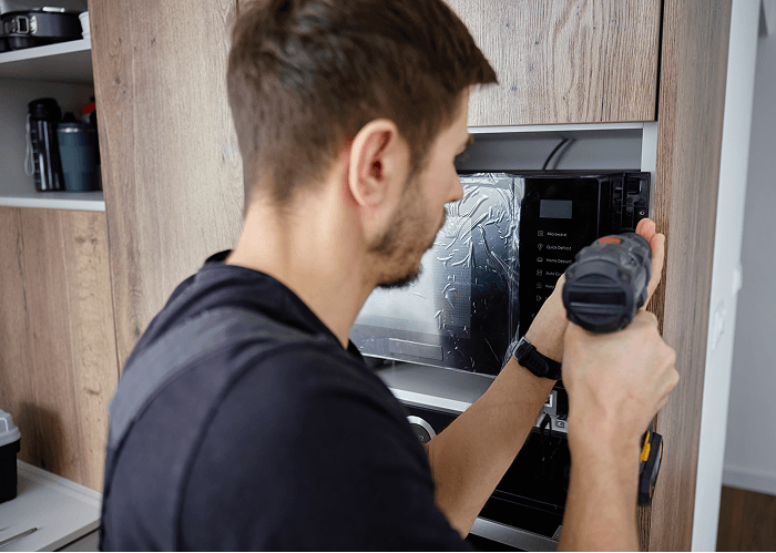 Man installing a kitchen appliance