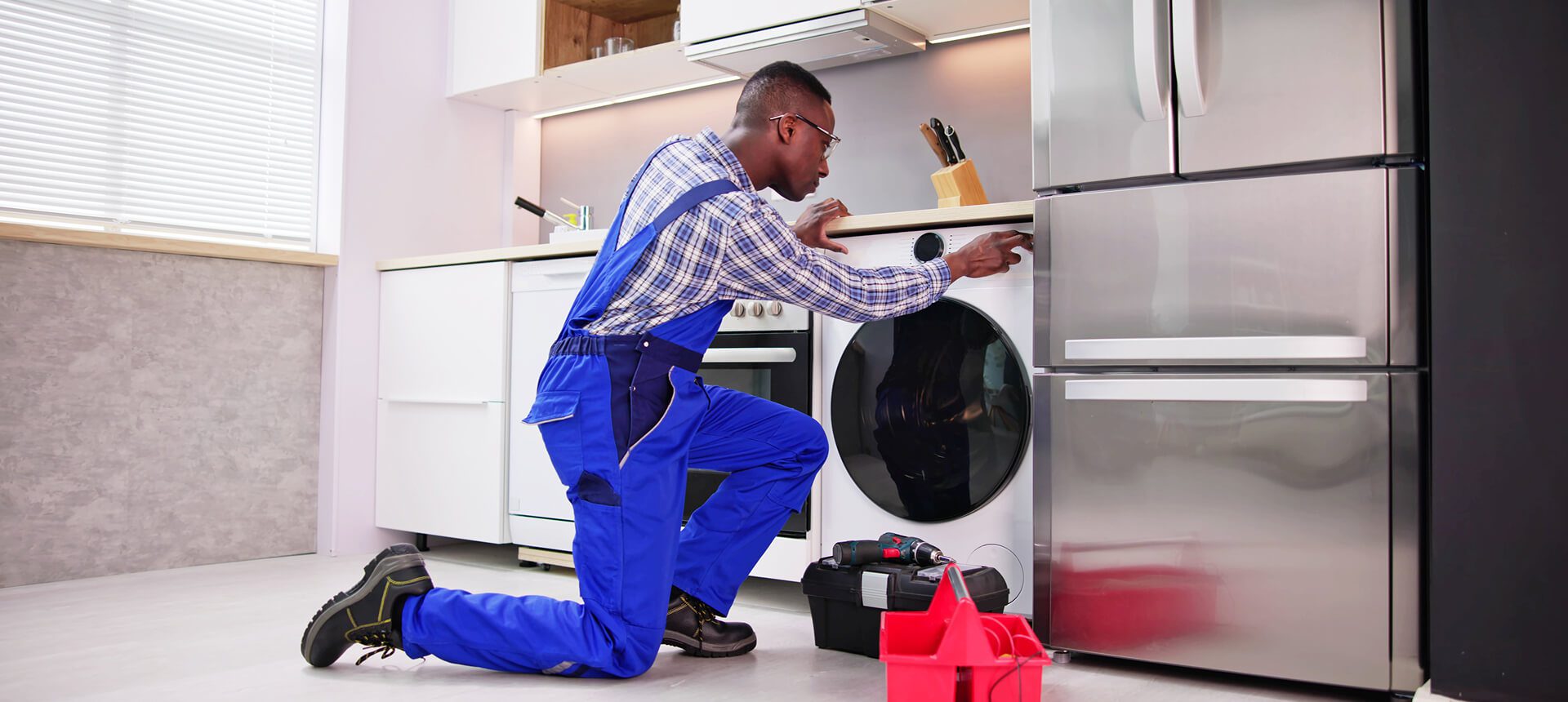 Man in blue overalls fixing appliance